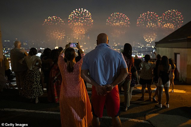 A view of a couple watching the Macy's 48th Annual Anniversary Fireworks in New York City from Weehawken, New Jersey