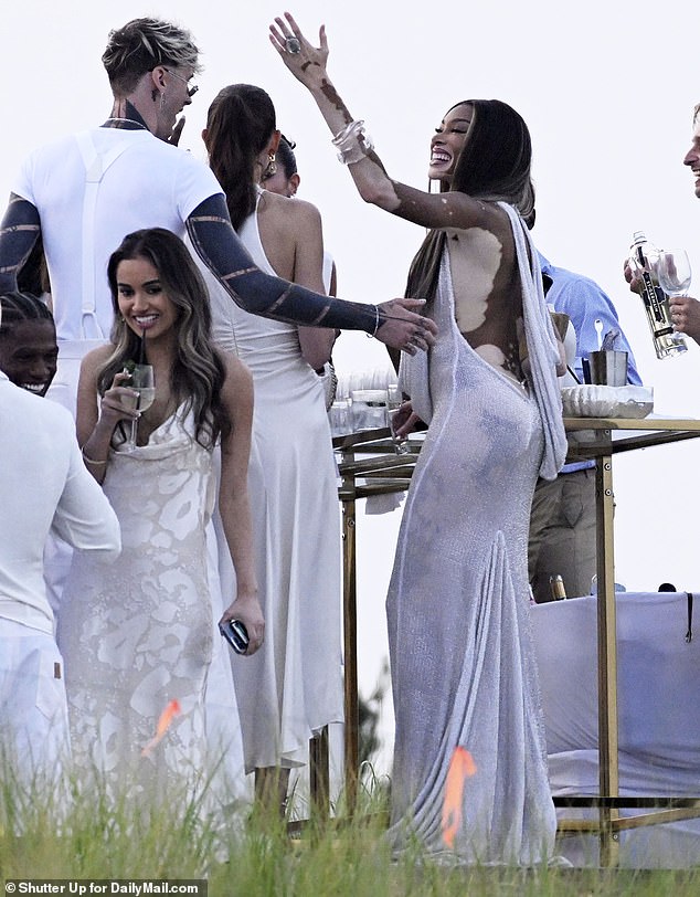 Winnie showed off her cleavage in the sparkling white dress with a cowl neckline and draped hood.