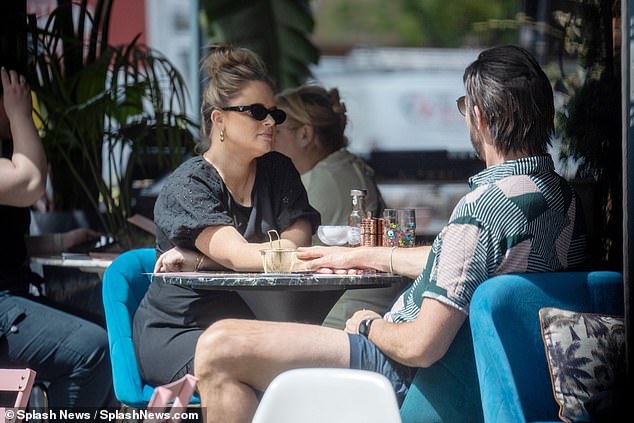 The new parents seemed more in love than ever and held hands at the table while chatting intensely.