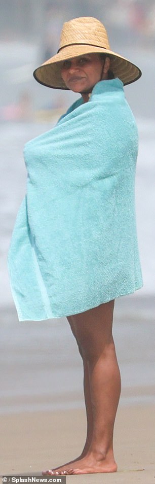 She wrapped herself up on the beach with the soft blue towel.