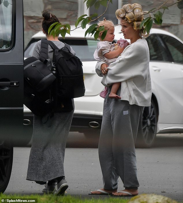 Arriving at the hotel, Molly was sporting a pair of grey sweatpants and sporting curlers in her hair as she lifted her 17-month-old daughter Bambi out of the car.