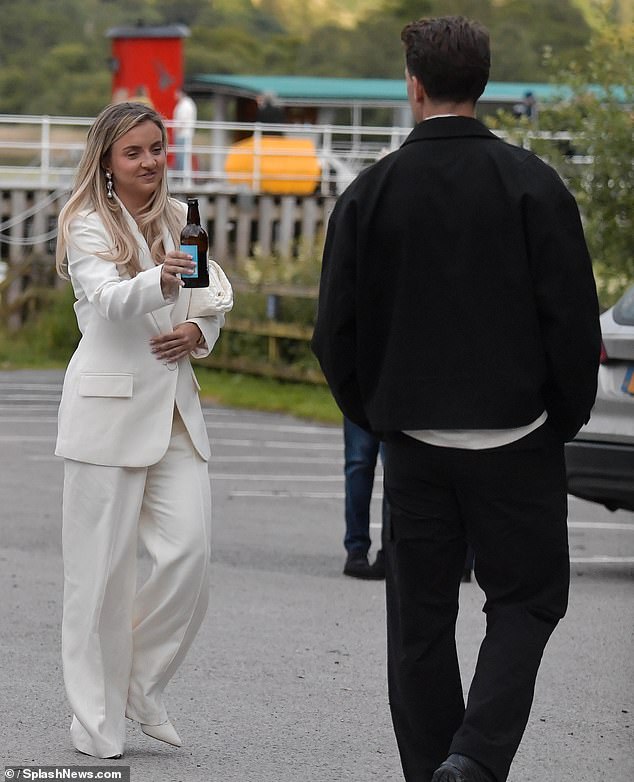 She carried her essentials in a white woven tote bag and styled her locks in voluminous waves as she got ready for her big day.