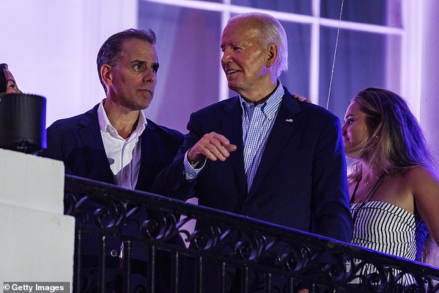 Biden speaks with his son, Hunter Biden, after fireworks on the National Mall with first lady Jill Biden and Vice President Kamala Harris' husband Doug Emhoff on the White House balcony.