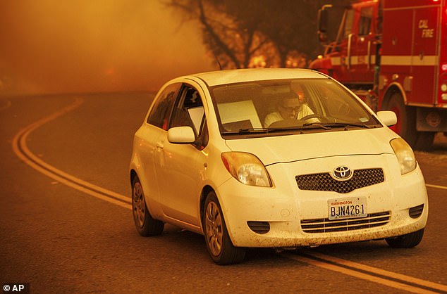 An unidentified resident, pictured above attempting to evacuate, is one of more than 28,000 who have been ordered to evacuate Butte County.