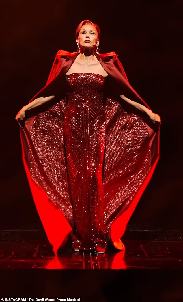 At first, Williams stands motionless with the jacket closed, but once she reaches the top of the stage, she quickly opens both sides to reveal a full-body look at the eye-catching red sequin dress, which perfectly matched the inner lining of her long coat.