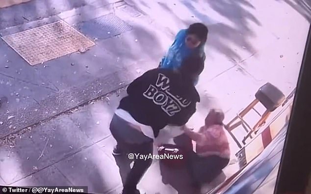 In the video circulating on social media, the woman follows another passerby with a bag and suitcase at her side. The woman looks at the man who is wearing a black hoodie, white shirt and black pants before being punched in the head and falling to the ground.