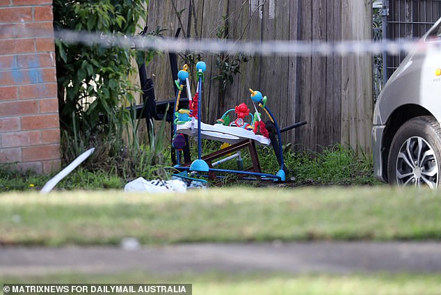 A baby walker was seen on the front lawn of the home, its colorful toys in stark contrast to the blackened house.