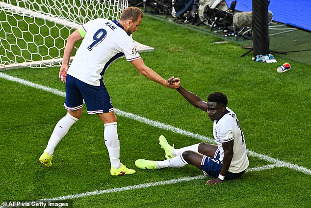 Kane gives Saka a helping hand, who caused 'problems throughout the game' for the Swiss with his pace