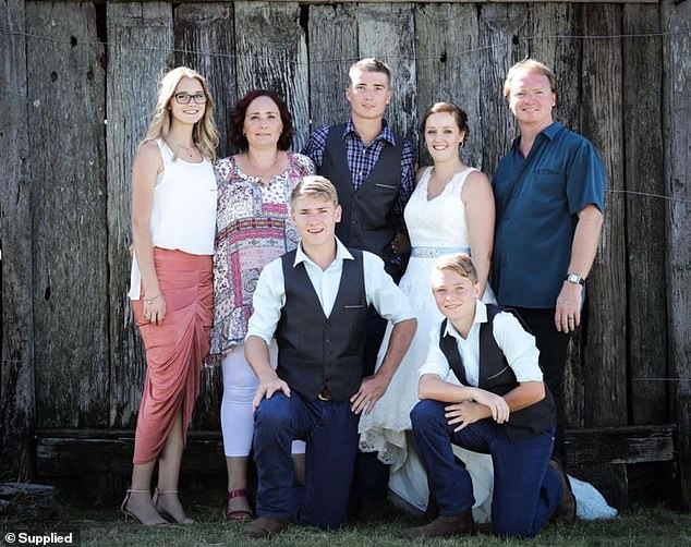 Olivia is pictured with her older brother Chris (standing alongside his wife Stefanie Harlow), her father David, her mother Jill and two younger brothers Scott and Ryan.