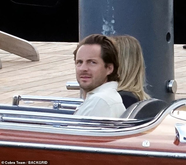 Tom looked dapper in a white shirt as he sat on the boat with his gorgeous wife Margot.