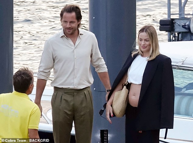 MailOnline has obtained photos of the star proudly showing off her small but visible baby bump during the couple's holiday in Italy.