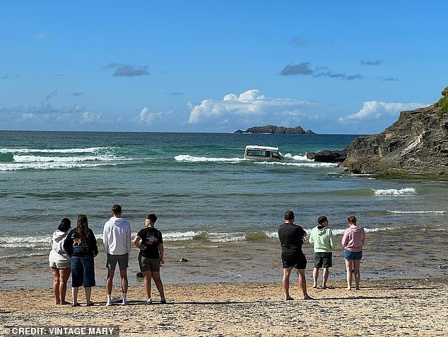 The audience watches as the ice cream truck is tossed around by the waves.