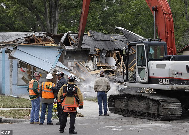 Demolition experts look on as the house, which was destroyed on March 3, 2013, after a sinkhole opened beneath it late in the afternoon and swallowed Bush, 37, in Seffner.