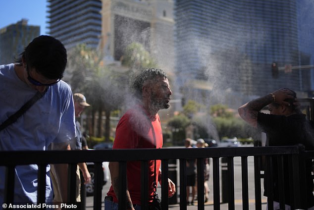 People cool off with mist sprayers on the Las Vegas Strip on Sunday