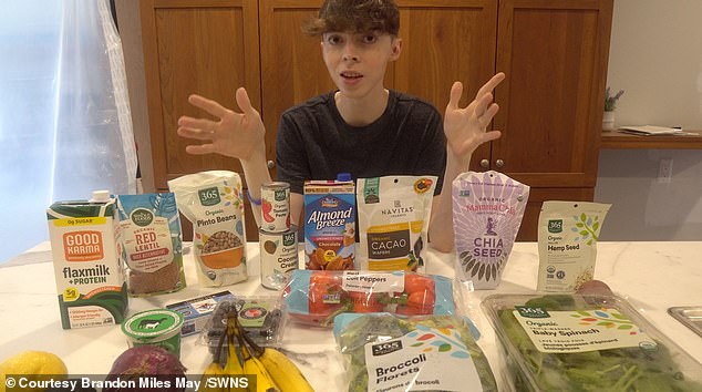 A recent photo of the 35-year-old man standing next to a selection of healthy foods. When he was 15, he started drinking green tea and eating more plant-based foods.