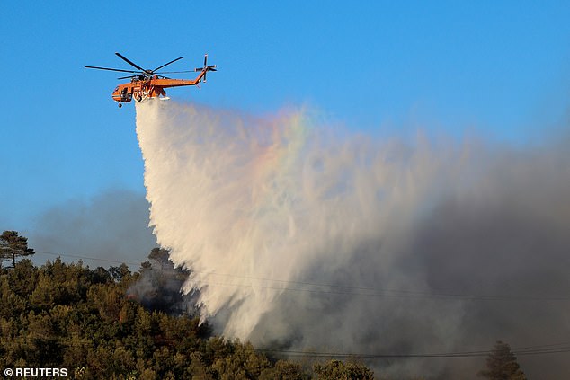 Long periods of hot, dry weather and lack of rain increase the likelihood of wildfires. Pictured, a firefighting helicopter drops water as a wildfire burns in Stamata, near Athens, Greece, June 30, 2024.