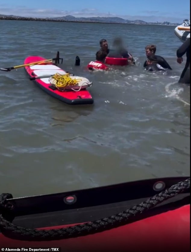 The frantic rescue effort by a coalition of police and firefighters is then shown, with one man seen almost completely underwater as they worked to free him.