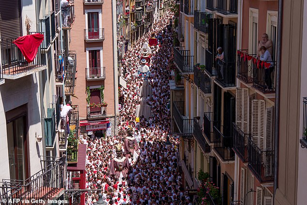 Revelers attend the parade "Giants and big headeds" (Giants and big heads) within the framework of the San Fermin Festivities in Pamplona on Sunday