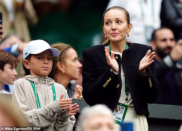 His wife Jelena Djokovic (right) looked a little uncomfortable as Djokovic faced the crowd.