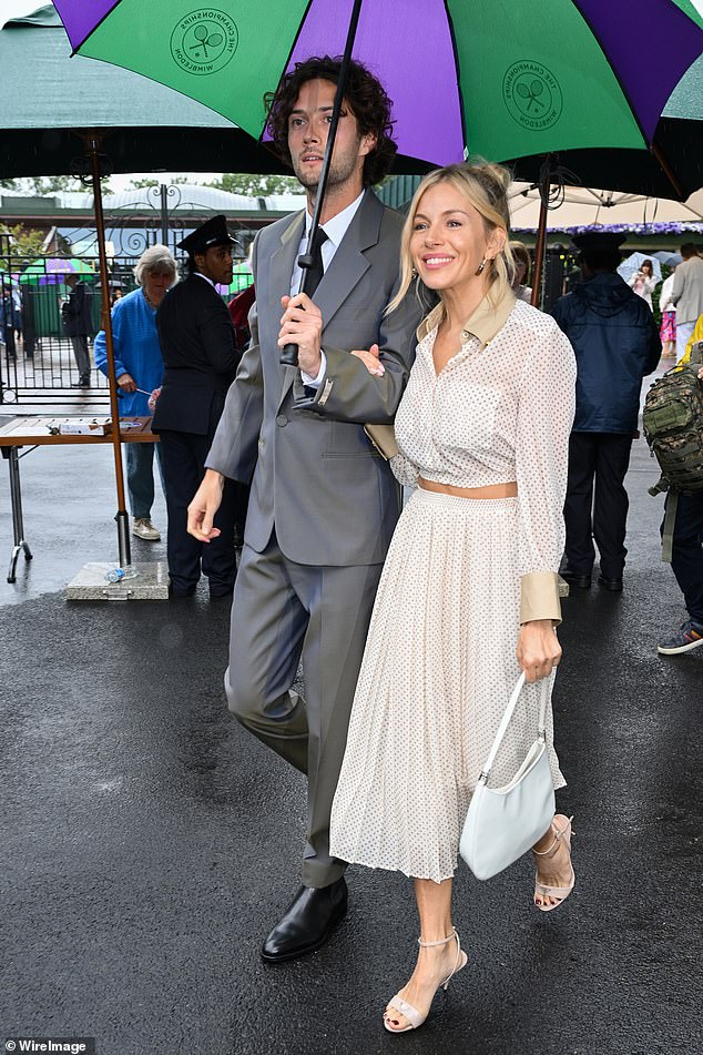 The couple made a stylish arrival at the iconic spot, as they were photographed walking arm-in-arm under a branded umbrella.