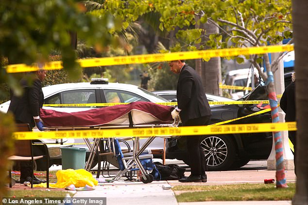 A victim of a multiple stabbing is led away as officers investigate the scene at the corner of 16th Street and Pecan Avenue in Huntington Beach.