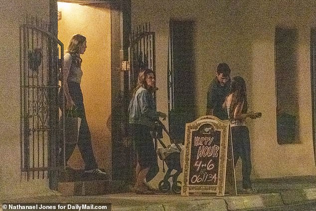 Hilaria leaving the restaurant after enjoying the best Italian food in New Mexico.