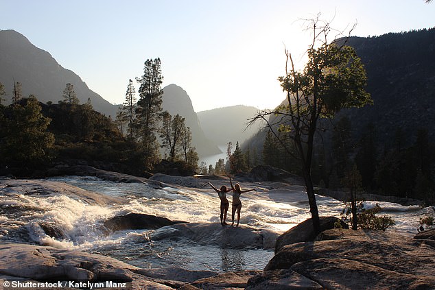 Two women pose for a photo in Rancheria Falls, where the toilet paper was found.