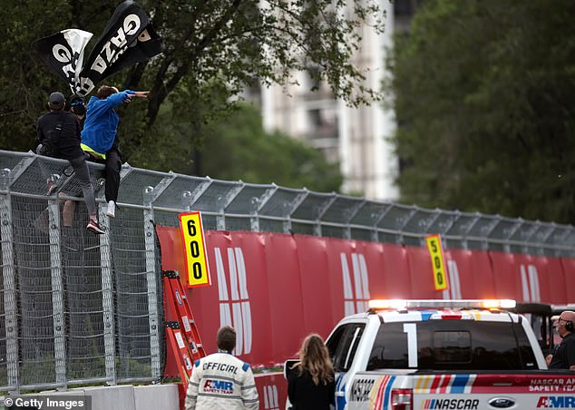 The man in the blue sweatshirt is seen snatching the flag from one of the protesters.