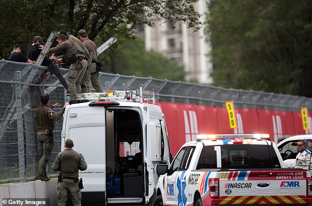 Police scaled the fence about 40 minutes after the protesters chained themselves to it and arrested them on suspicion of trespassing.