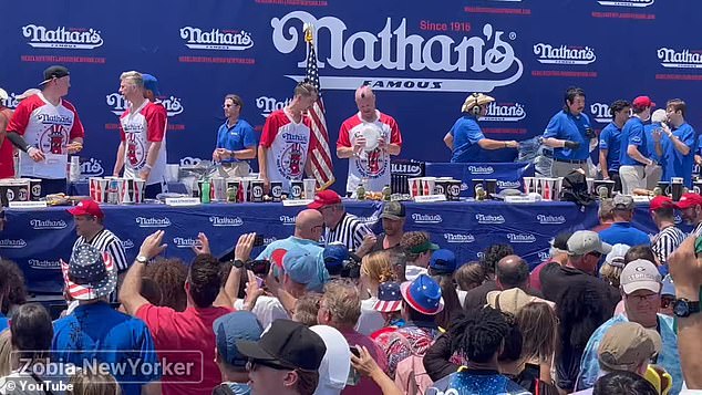 Video of the competition shows Wehry (center) holding a paper plate while standing on stage.