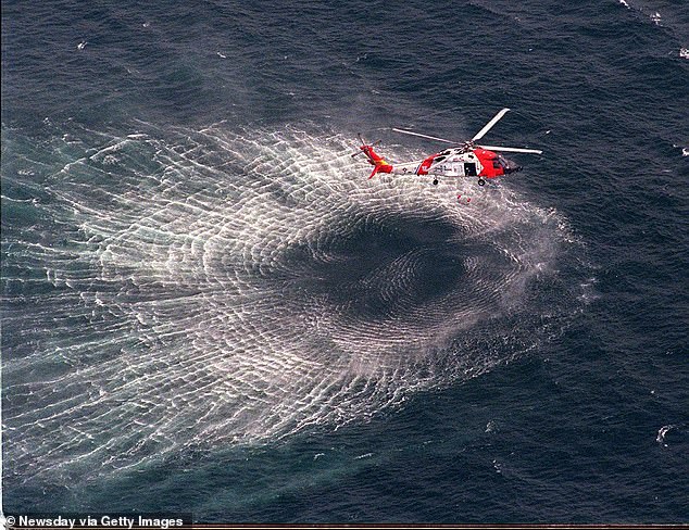 July 17, 1999: A Coast Guard helicopter pulls a rescue swimmer from the water during the search for the wreckage of JFK Jr.'s plane.