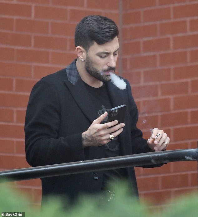 The 33-year-old professional dancer wore a black coat along with a matching T-shirt and jeans as he checked his phone.