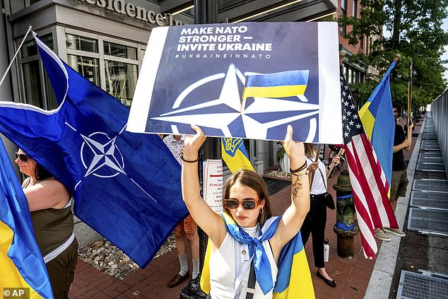 Ukrainian refugee Mariia Hlyten holds a sign outside the NATO summit in Washington