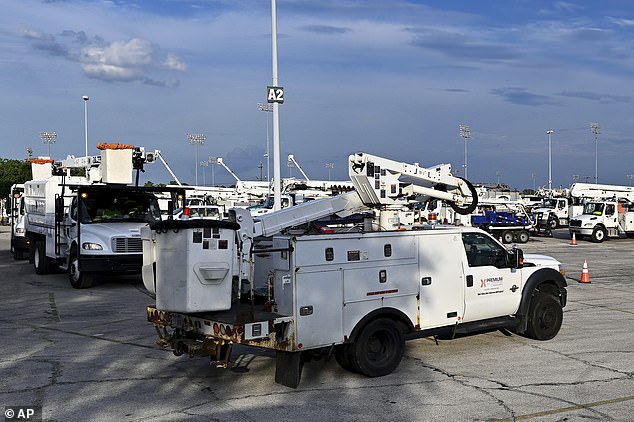 Utility trucks remain parked at a CenterPoint Energy staging facility at a gas station instead of working to restore power.