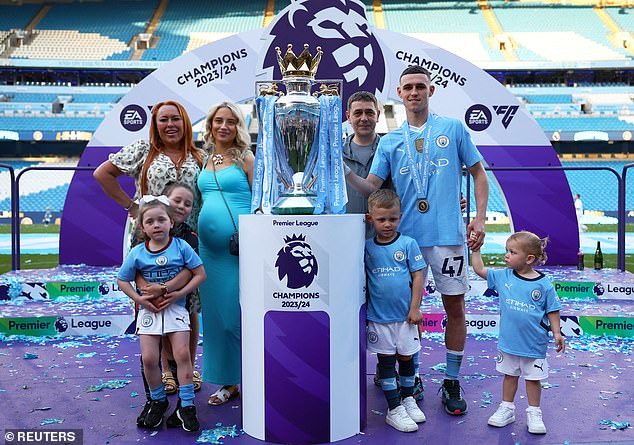 Phil stands with his girlfriend Rebecca Cooke next to the Premier League trophy, while holding hands with Ronnie and his daughter, True.