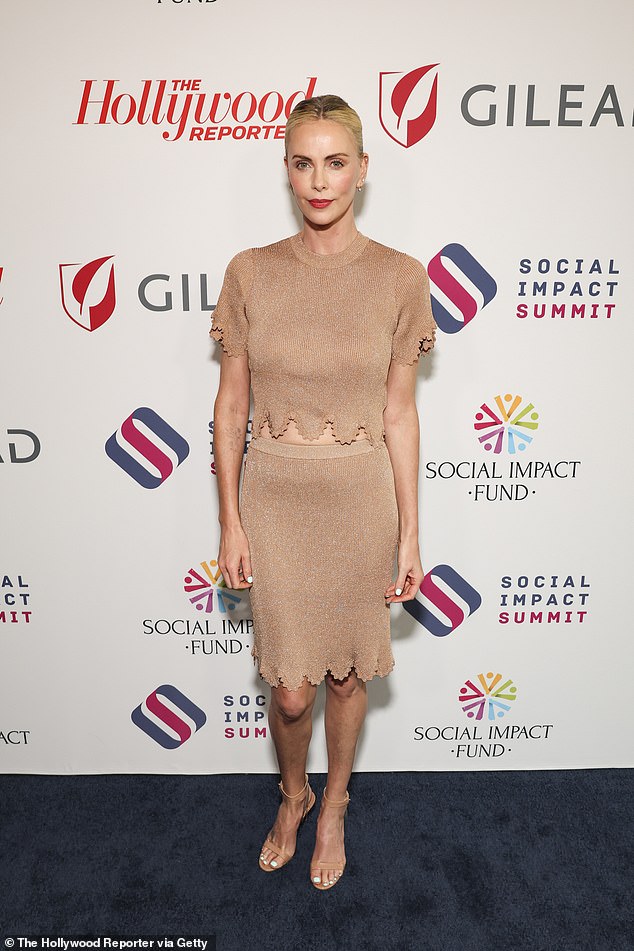 Theron opted for a nude-toned ensemble consisting of a short-sleeved top that revealed her toned midriff.