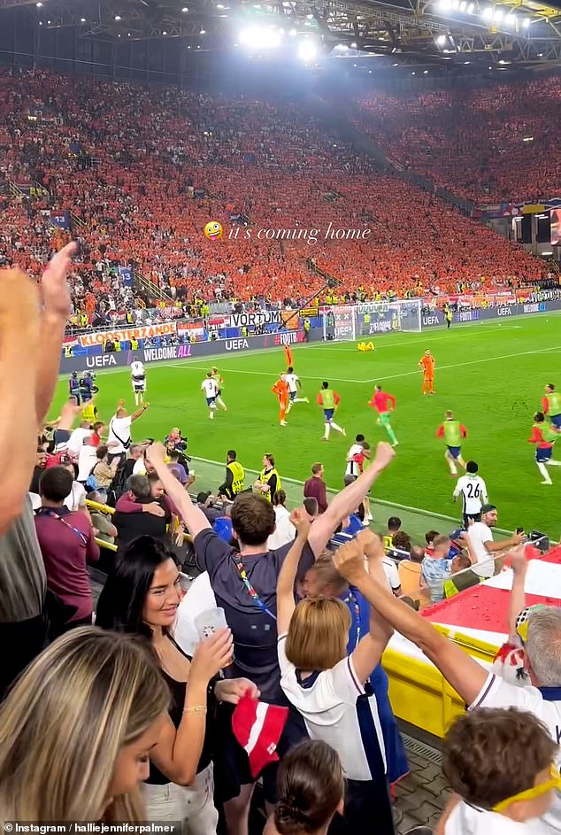 Annie is pictured in the corner smiling as she takes a sip from her cup. The rest of the stadium roared with joy as they celebrated England's victory over the Netherlands.