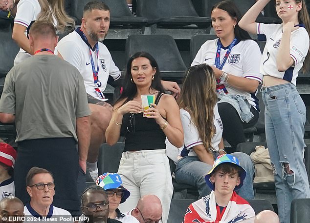 Annie, pictured, dressed down for the game in a strappy black top and white jeans. She wore her shiny black hair down and completed the look with large hoop earrings.