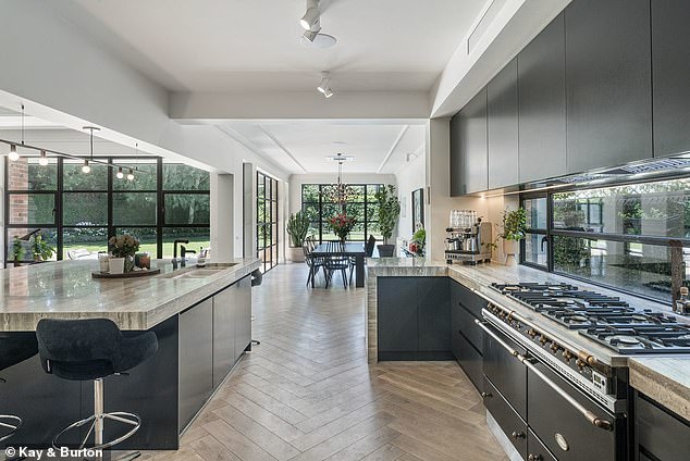 Designed in a classic Tudor Revival style, the beautiful home features impressively scaled living spaces and floor-to-ceiling windows. Pictured: the kitchen