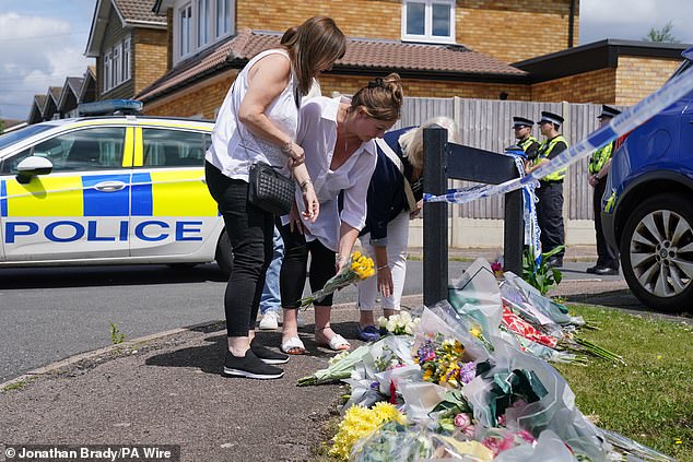 Close friend Lea Holloway (centre) leaves flowers at Ashlyn Close in Bushey, Hertfordshire