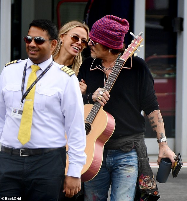 The 61-year-old actor lived up to his rock star image, carrying his guitar while flanked by a glamorous woman.