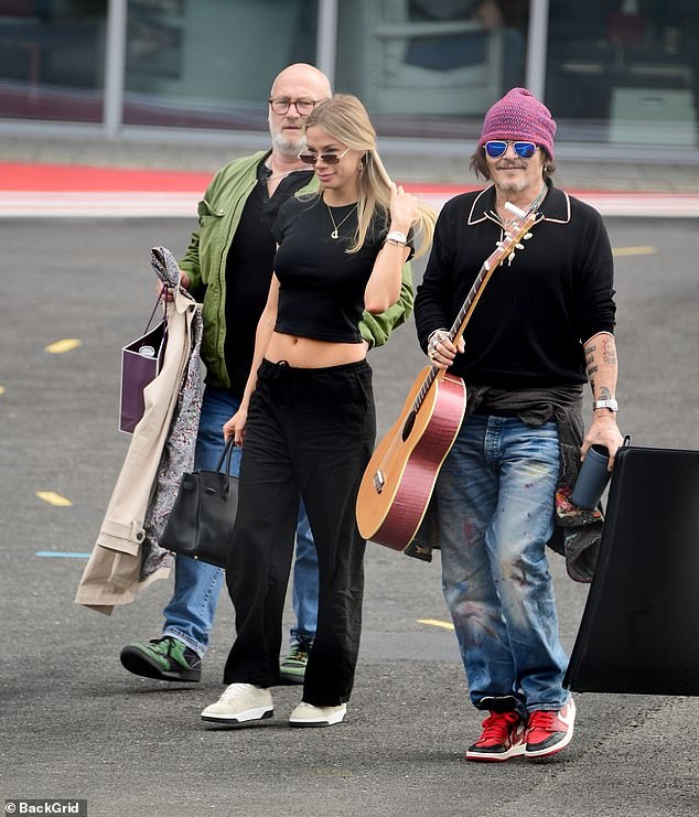 He looked cool and grungy in a red beanie, baggy jeans, sneakers and sunglasses and holding his six-string guitar to maybe serenade his potential new love interest.