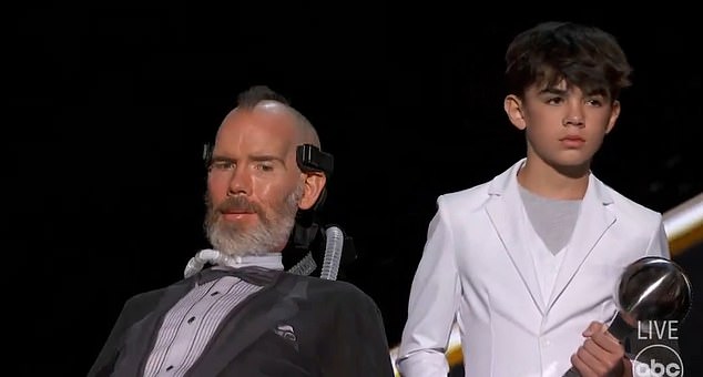 Gleason's speech was delivered by computer and was accompanied by his son, Rivers (right).