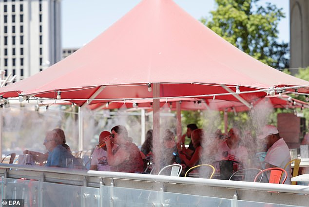 Visitors dine under fog to stay cool in record-breaking heat in Las Vegas as excessive heat warning issued