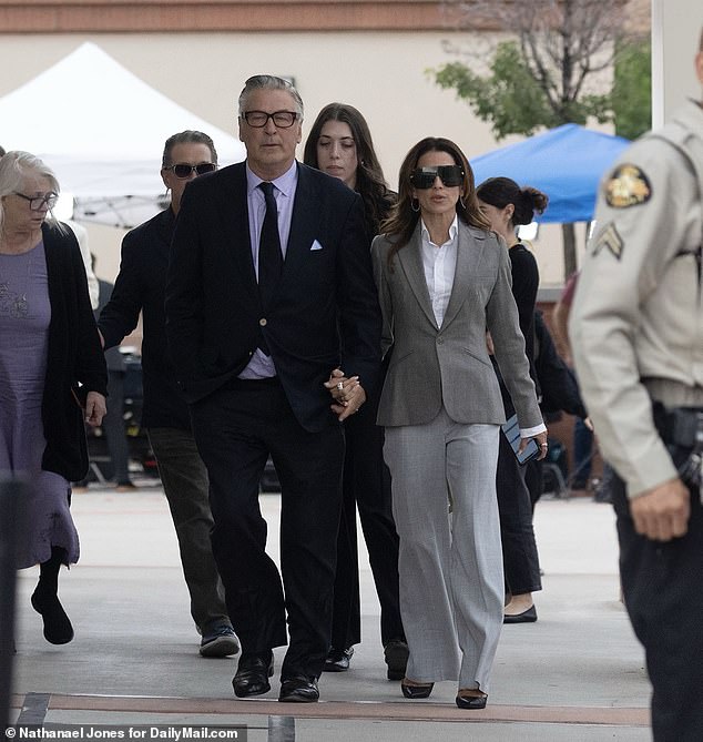 Baldwin holds hands with his wife Hilaria as he leaves court on Friday, moments after a judge dismissed his murder case.