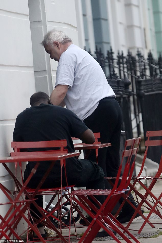 Eamonn cut a casual figure in a grey T-shirt and black trousers as he struggled to get into a London cafe on Friday.