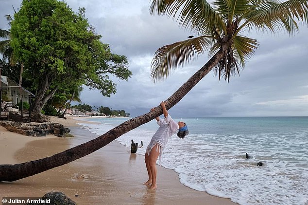 Julian's wife Susan, seen here, enjoying herself outside the Carib Beach Bar in Christ Church.