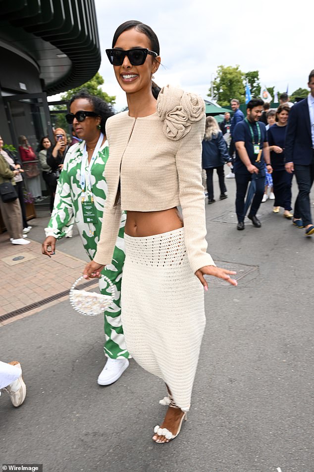 She carried her belongings in a small white bag and hid her eyes behind black sunglasses as she posed for photos.