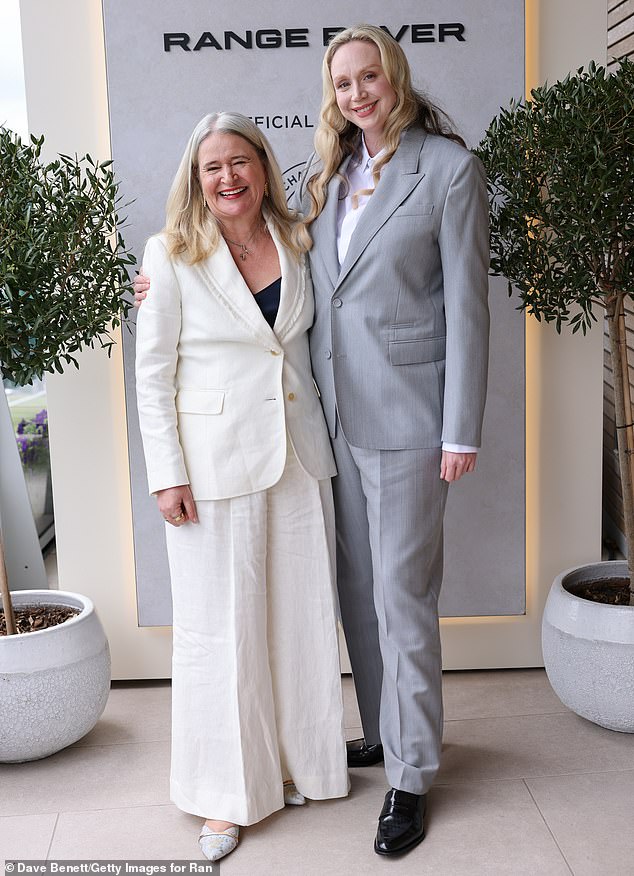 She paired the sleek suit with a pair of shiny black leather shoes as she posed with Harper's Bazaar editor-in-chief Lydia Slater.