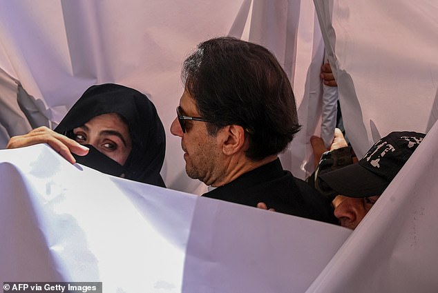 Former Pakistani Prime Minister Imran Khan and his wife Bushra Bibi arrive at a high court in Lahore on May 15, 2023. Khan has since been embroiled in more than 150 legal cases, including for inciting violence.